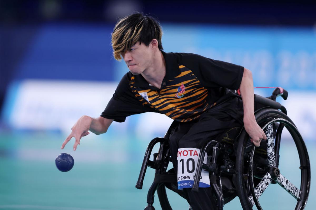 A male boccia athlete throws a blue ball at the Tokyo 2020 Paralympic Games.